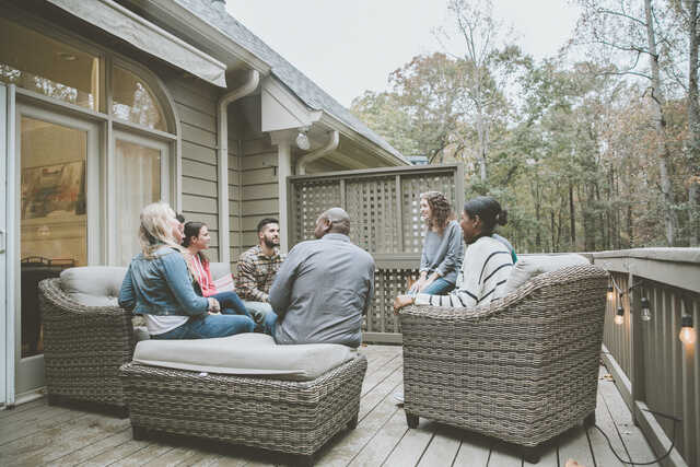 diverse group of married couples meeting outside on a deck in the fall