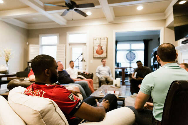 men's community group meeting in a living room