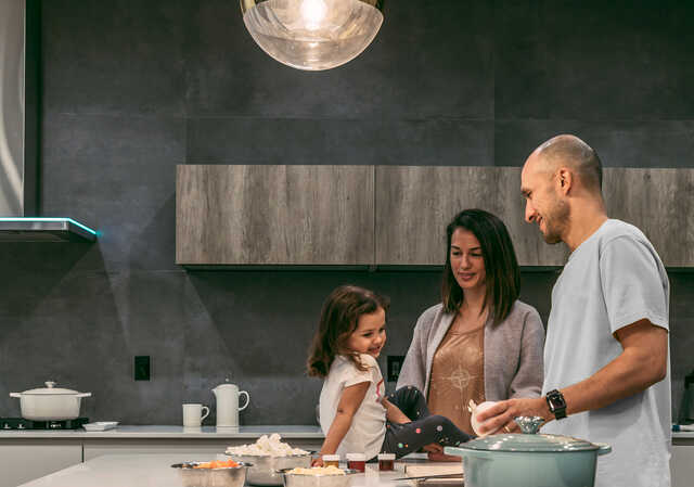 parents with daughter sitting on kitchen counter