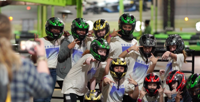 group of middle schoolers with helmets on heads posing for picture